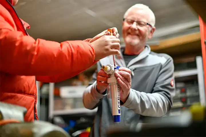 Zwei Männer bei der Arbeit an einem Wasserfilter.