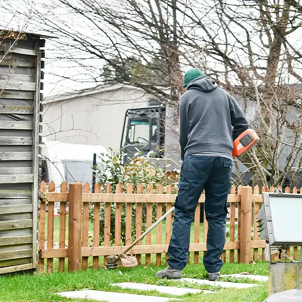 Junger Mann trimmt den Rasen