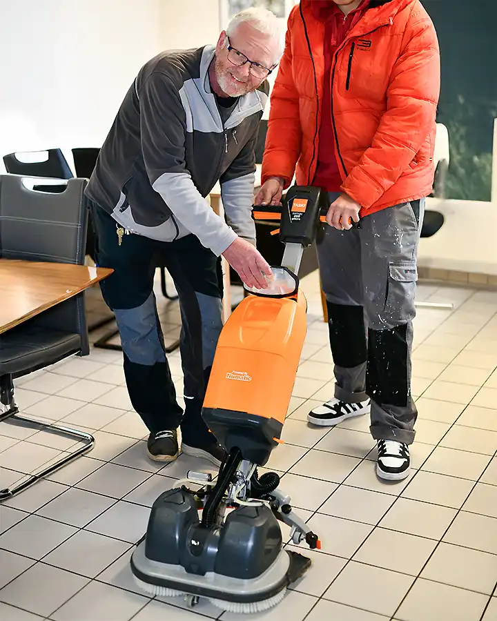 Zwei Männer übernehmen die gründliche Reinigung eines Plattenboden