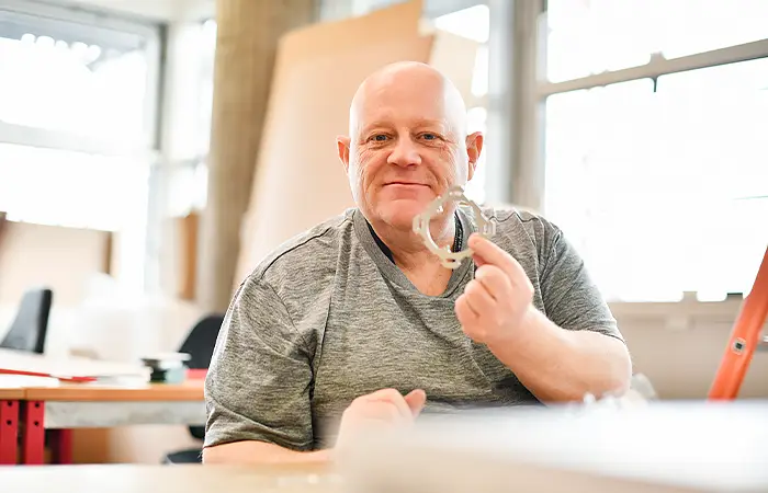 Mann mit Glatze arbeitet in Konfektion