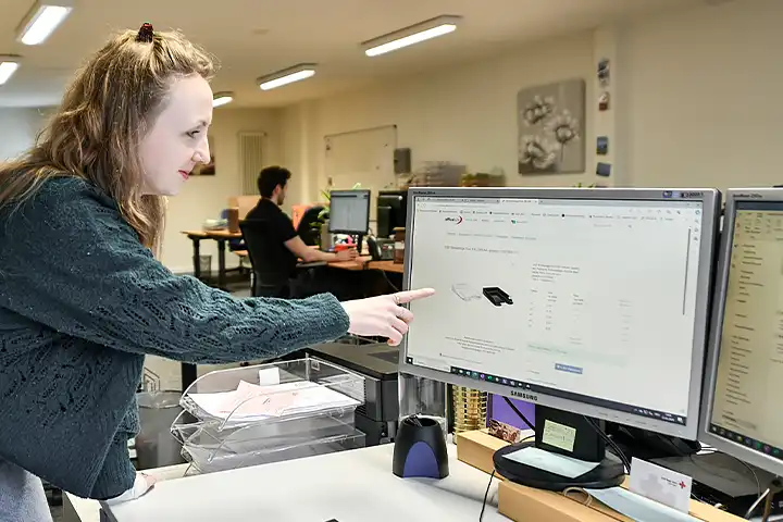 Eine blonde Frau erklärt am Computer