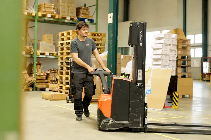 junger Mann arbeitet in Logistik mit Stapler